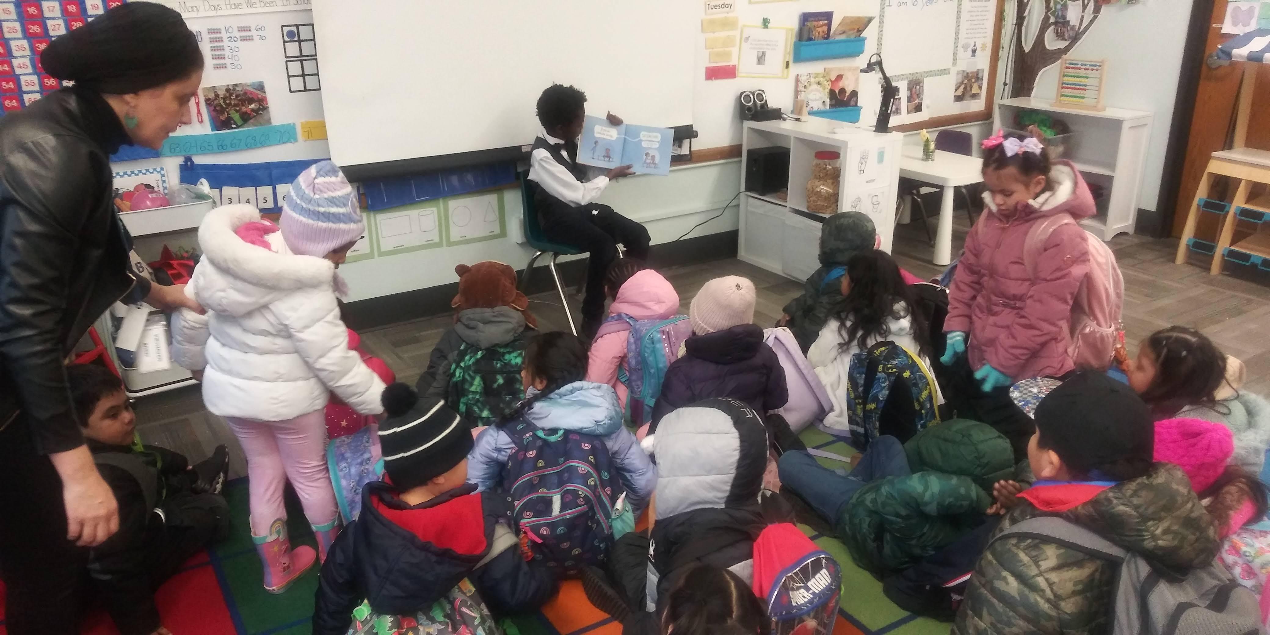 Middle schoolers reading to elementary children